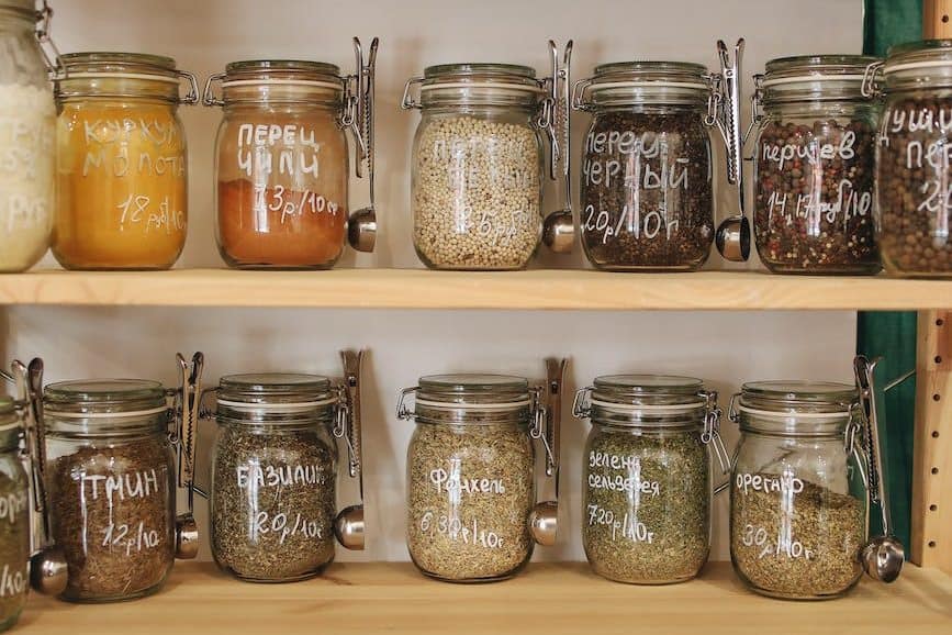 clear glass jars on white wooden shelf