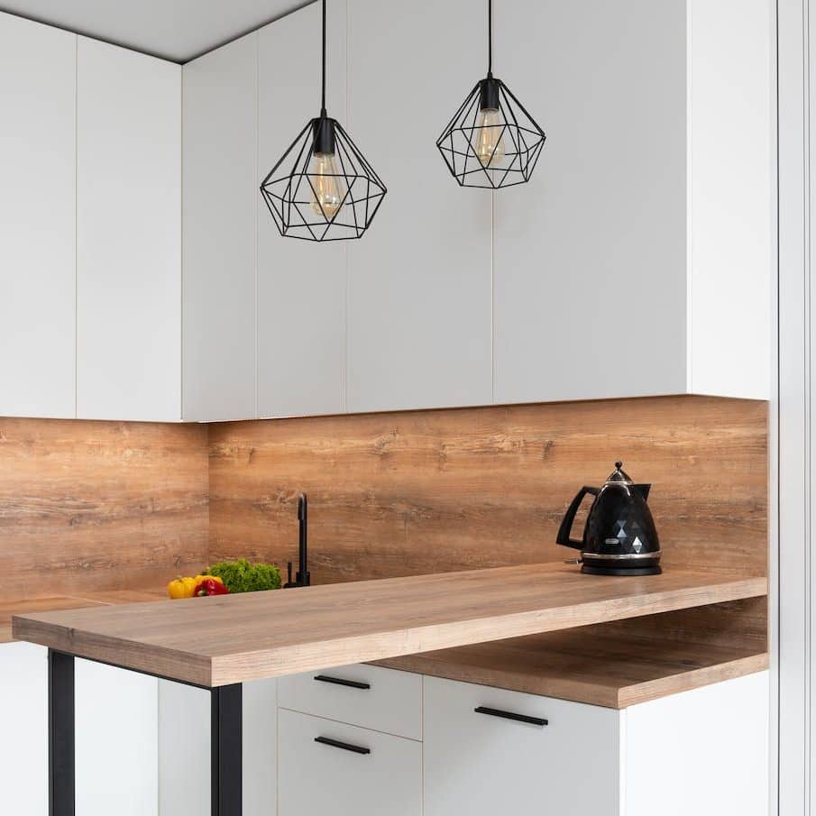 geometrical shimmering lamps hanging over wooden table of kitchen